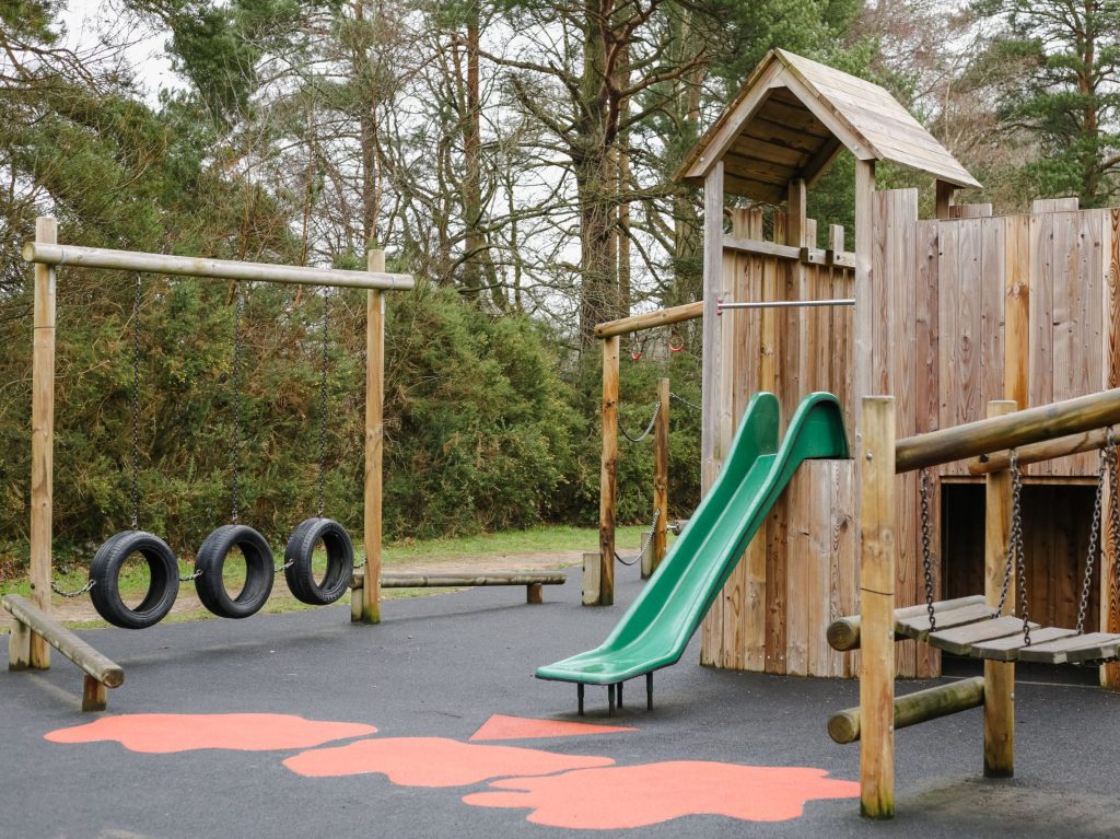 Image of wooden fort at calthorpe park - showing slide and tire course