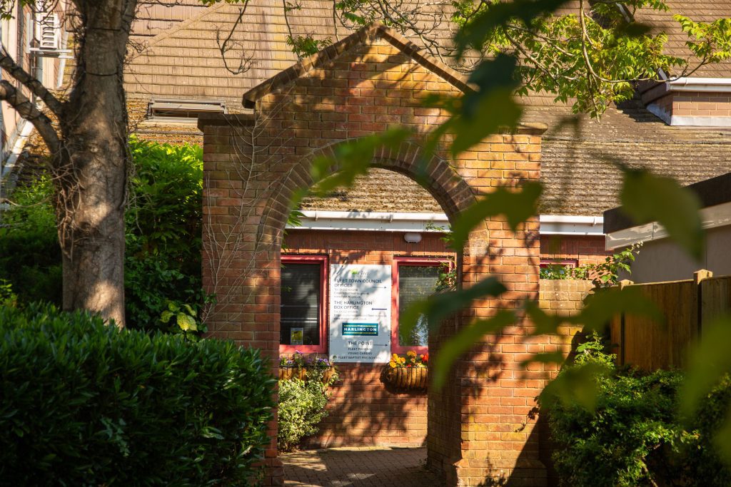 Image of a brick archway with a council office sign attached to the wall behind