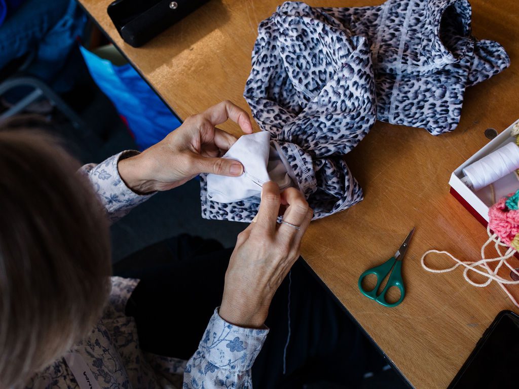 Image of someone sewing up a clothing item