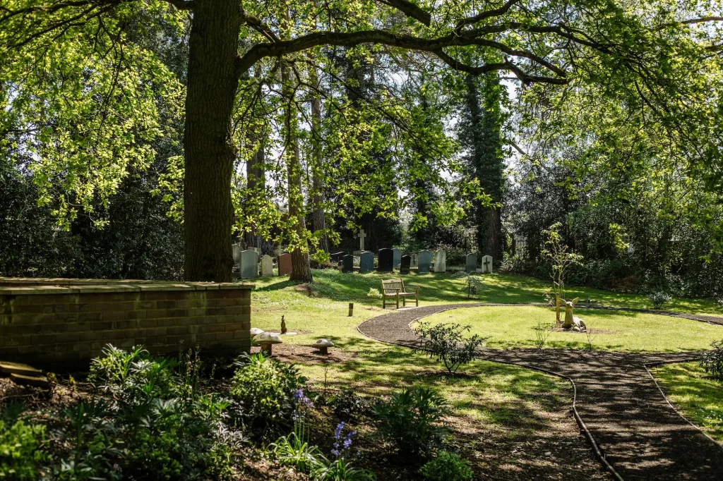 Image of fleet cemetery children's area on a sunny day - circular path with a deer statue in the middle surrounded by greenery