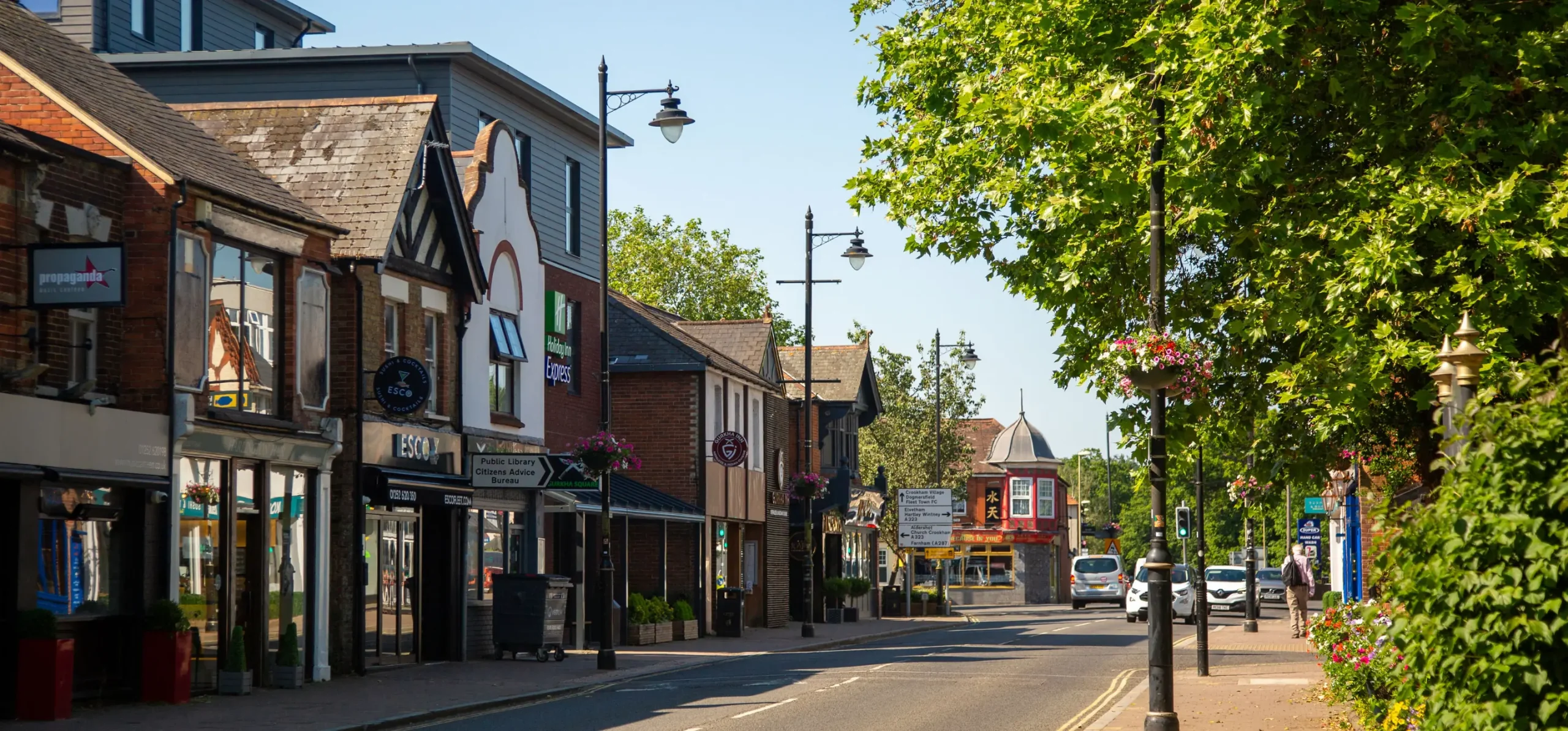 image of fleet high street showing restaurants, cars and bright floral displays