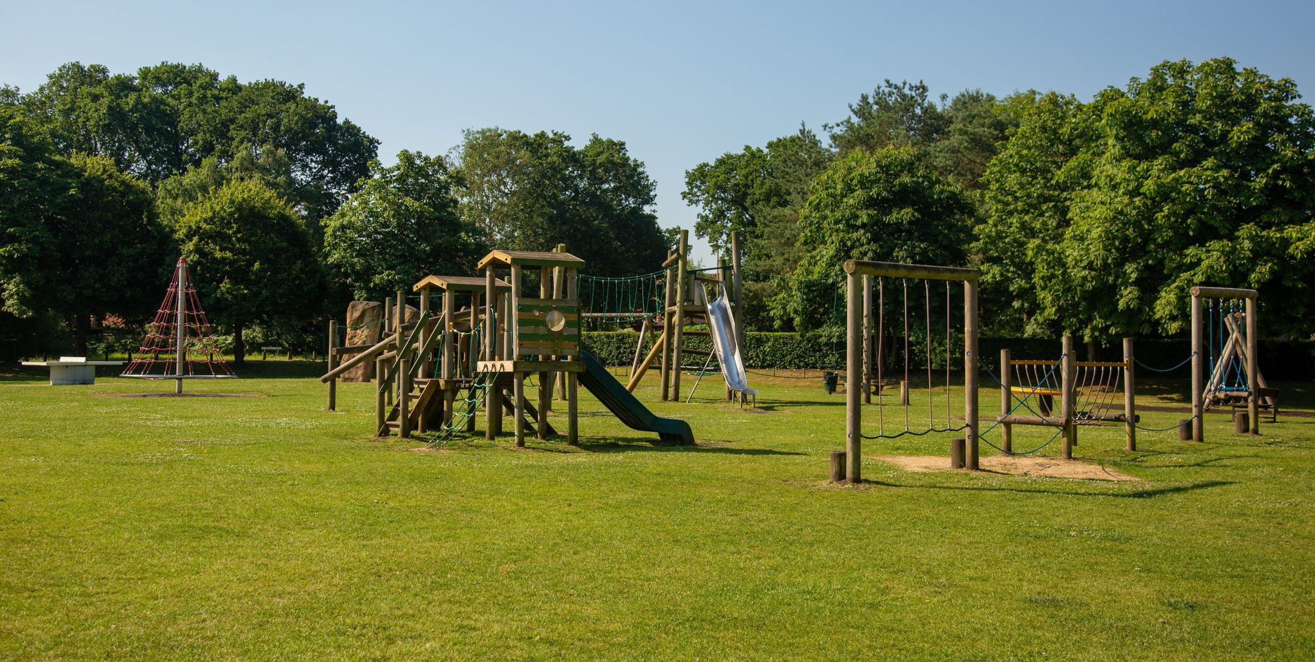 Image of wooden play equipment at Ancells Farm park including climbing frames, zip wire, slides and swings