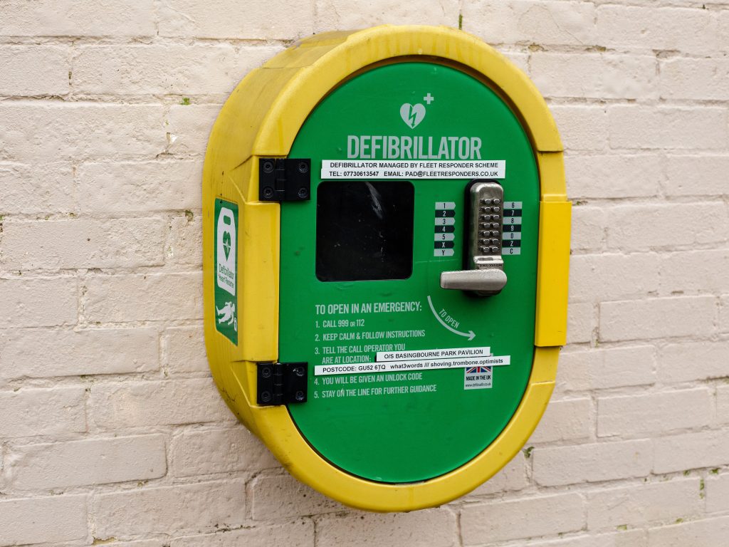 Image of a defibrillator on a white brick wall