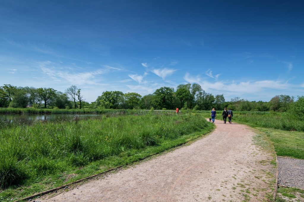 Image of people walking along at footpath at Edenbrook Country Park taken of on a sunny day