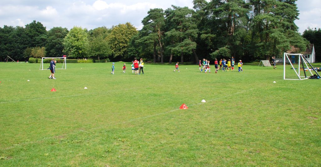 Image of children playing football on the grass at Basingbourne Park