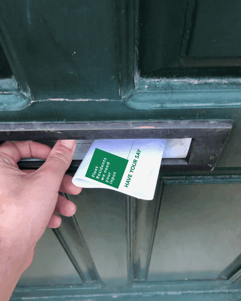 Image of flyer being posted through letterbox in door