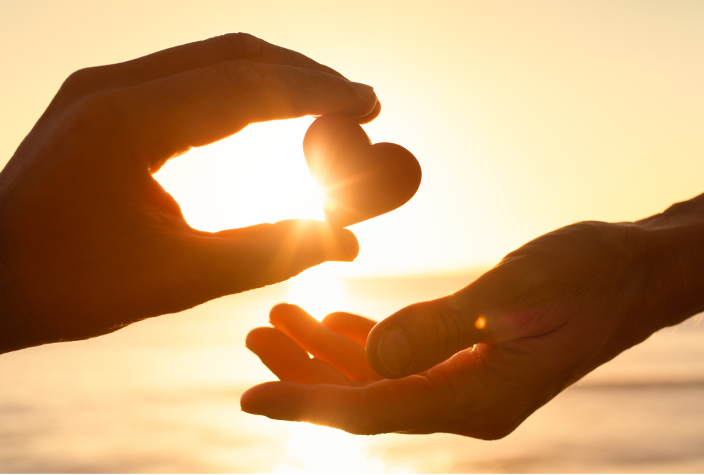 image of hands holding up heart shaped stone
